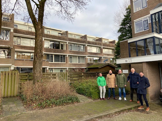 Zonnepanelen met appartementen op de achtergrond